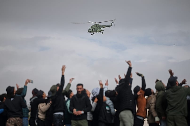 An army helicopter flies overhead during a parade by the new Syrian army marking the first anniversary of the ousting of the Bashar Assad regime in Damascus, 8 December 2025
