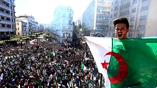 جزائري يهتف وهو يحمل العلم الوطني خلال احتجاج في الجزائر العاصمة، الجزائر،