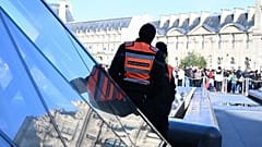ملف: أفراد أمن خاص يراقبون الناس وهم يصطفون خارج متحف اللوفر، باريس، 30 أكتوبر/تشرين الأول 2025