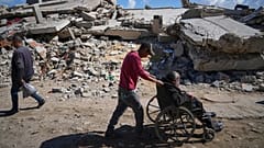Um homem empurra o seu pai para o hospital Shifa na Cidade de Gaza para fazer diálise, 14 de abril de 2025