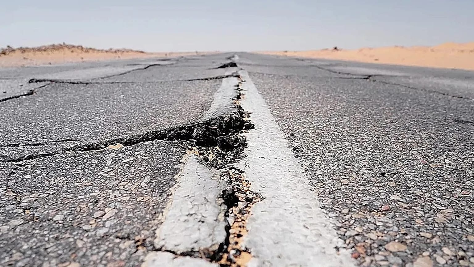 Bu stok fotoğrafta bir kara yolunda deprem sonrası yarıklar oluştuğu görülüyor. 