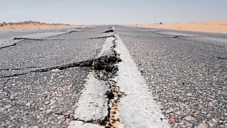 Bu stok fotoğrafta bir kara yolunda deprem sonrası yarıklar oluştuğu görülüyor. 