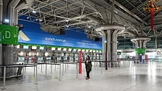 Una mujer camina por el vestíbulo casi desierto del aeropuerto de Lisboa al inicio de una huelga general.