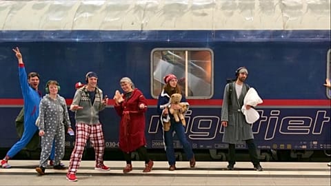 In this 2024 photo, protestors pose in their pyjamas in front of a train in Berlin.