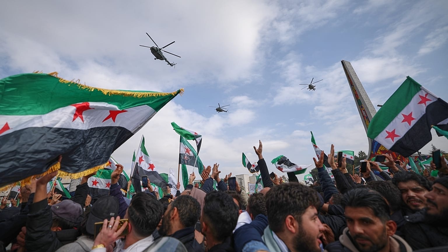 تحلّق مروحيات الجيش فوق رأس موكب للجيش السوري الجديد بمناسبة الذكرى السنوية الأولى لإطاحة نظام بشار الأسد في دمشق، سوريا، يوم الاثنين 8 ديسمبر 2025. 