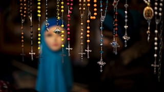 Auf einem Marktstand in Den Haag (Niederlande) werden Rosenkränze zum Verkauf angeboten, neben einer Schaufensterpuppe, die ein Kopftuch trägt. 4. März 2017