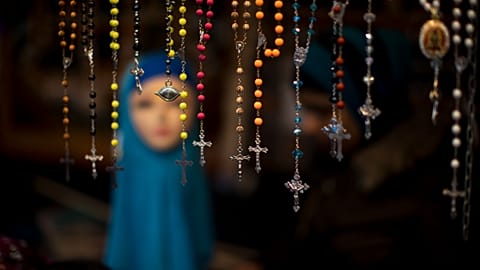 Des chapelets sont proposés à la vente sur un stand de marché à La Haye (Pays-Bas), à côté d'un mannequin portant un foulard. 4 mars 2017