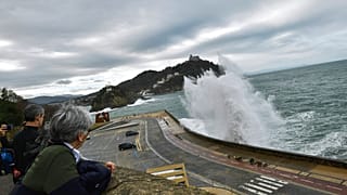 مشاهدون يراقبون موجة عملاقة تصطدم بالحواجز البحرية خلال ارتفاع المد في سان سباستيان، شمال إسبانيا، الأحد 22 ديسمبر 2019.