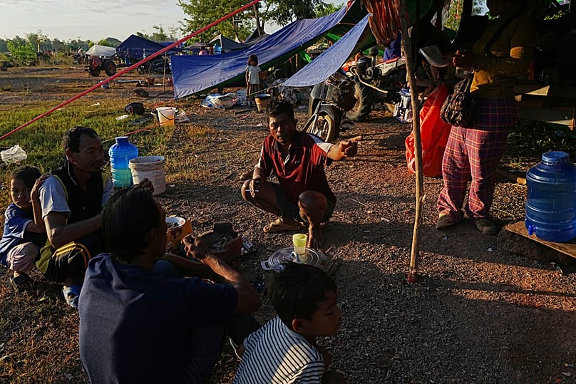People warm themselves around a bonfire as they take refuge in Siem Reap after fleeing from their homes following fighting between Thailand and Cambodia, Friday, 12 Dec, 2025