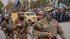 جنود من الجيش السوري الجديد يسيرون خلال عرض عسكري بمناسبة الذكرى السنوية الأولى للإطاحة بالرئيس السابق بشار الأسد، في دمشق، سوريا، الاثنين 8 ديسمبر/كانون الأول 2025. 