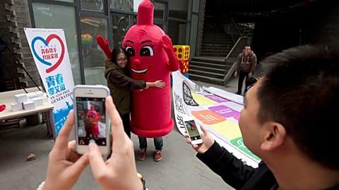 A participant hugs a condom mascot during an event to promote awareness of HIV testing ahead of the Dec 1 World AIDS Day, in Beijing, China, on Nov. 27, 2014.