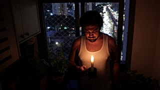Gustavo Stancial sostiene una vela en su casa durante un apagón en São Paulo, el jueves 11 de diciembre de 2025.