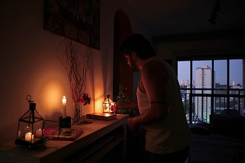 Gustavo Stancial enciende una vela en su casa durante un apagón en São Paulo, jueves 11 de diciembre de 2025. 
