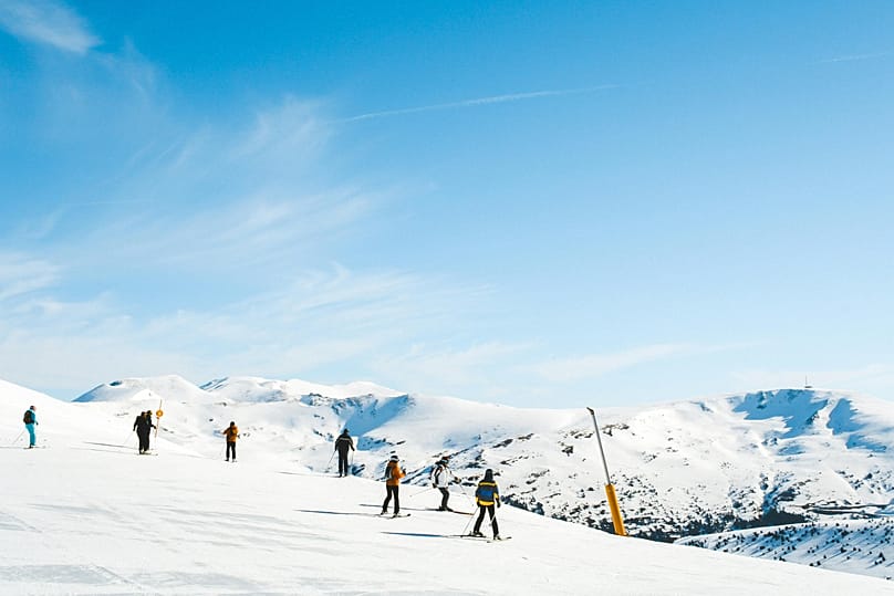 People skiiing on a slope in Spain