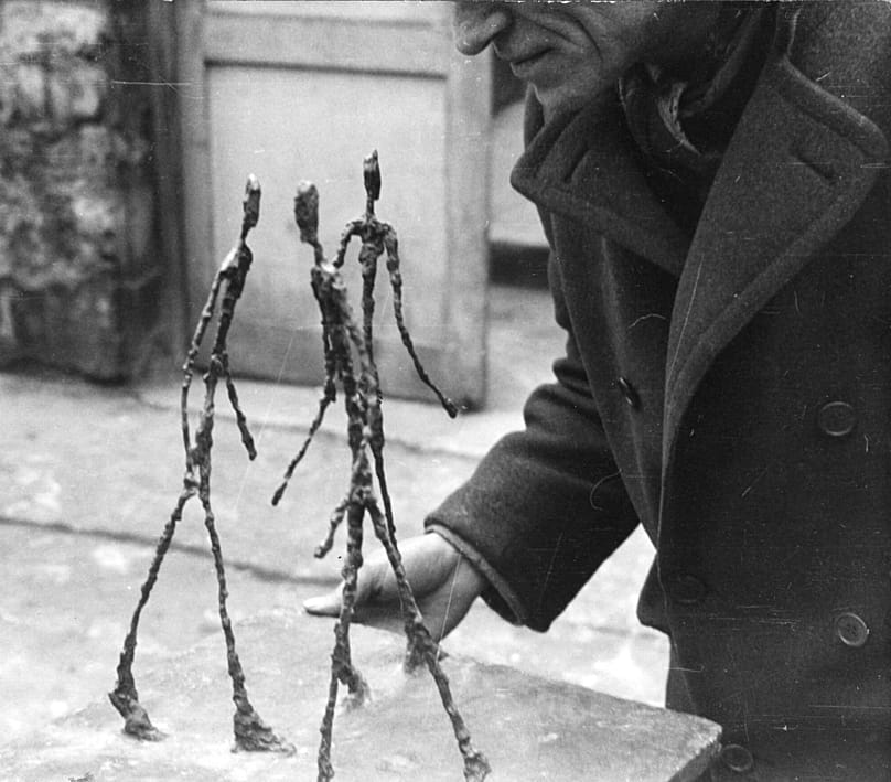 Alberto Giacometti holding Three Men Walking, 1940s. Photo: Anonymous. Archives Fondation Giacometti.