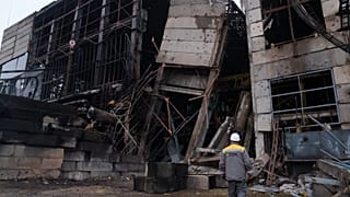 A worker walks in front of a production hall after a recent Russian missile attack at DTEK's power plant in Ukraine, on Wednesday, Dec. 10, 2025