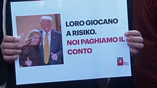 Баннер с изображением президента США Дональда Трампа и премьер-министра Италии Джорджи Мелони; на нем по-итальянски: «Они играют в „Risk“, а счет платим мы»