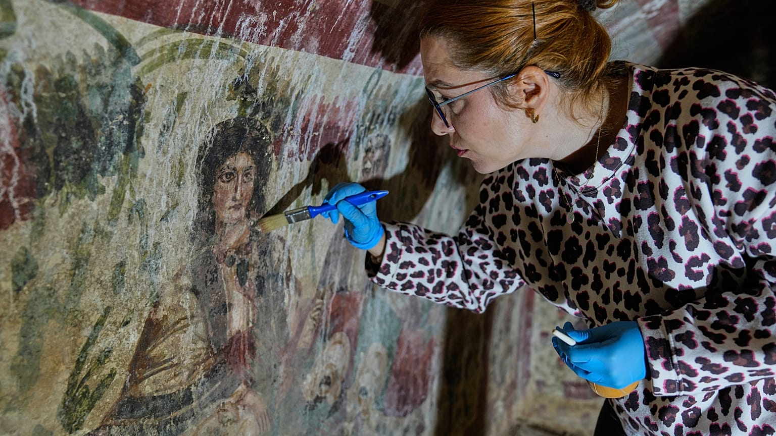 In einem Grab aus dem dritten Jahrhundert reinigt und restauriert ein Archäologe Fresken. Dort tauchte eine seltene frühe Darstellung Jesu als „Guter Hirte“ auf.