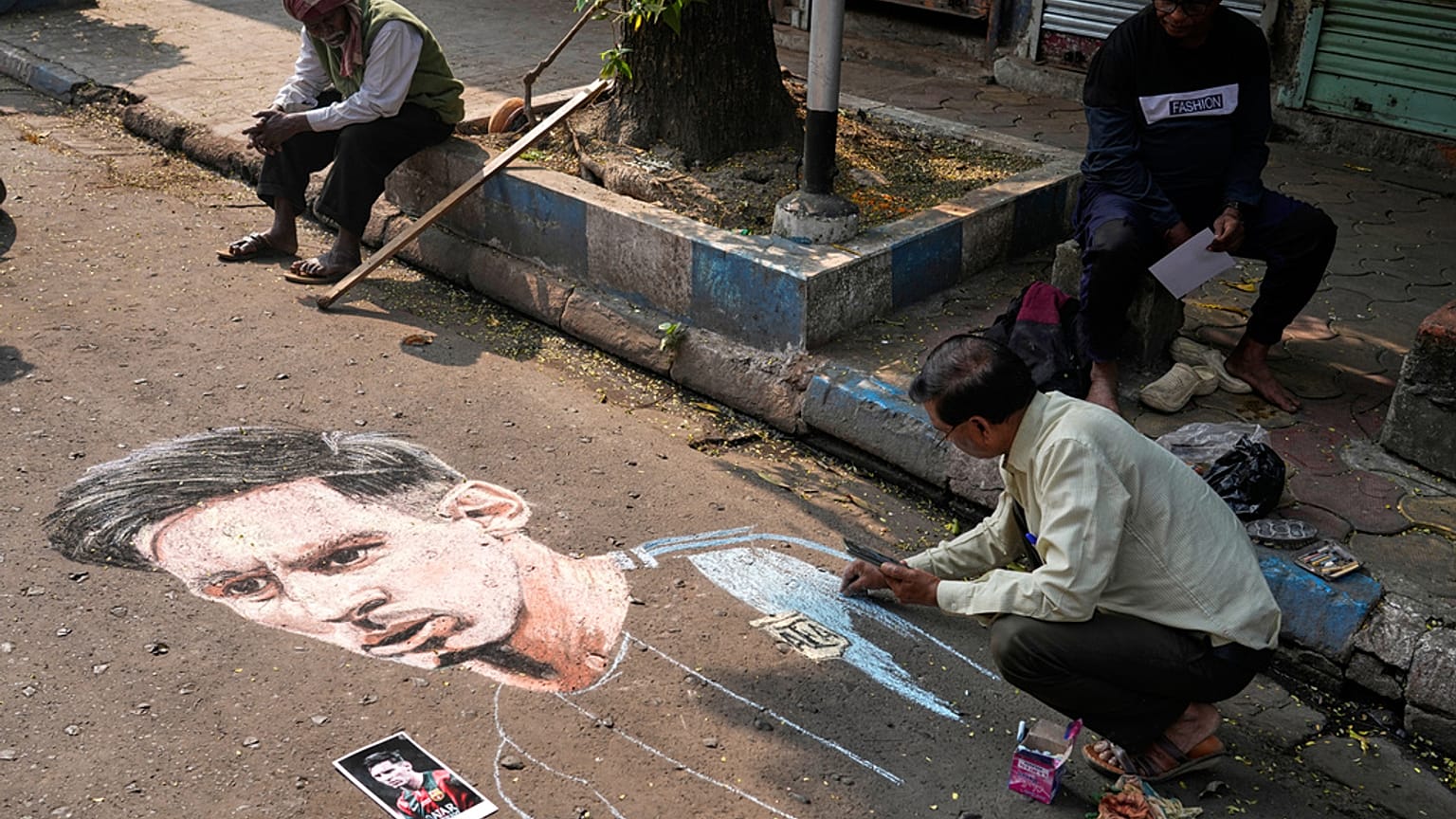 Egy indiai rajongó Messi-portrét rajzol egy kalkuttai utca aszfaltjára