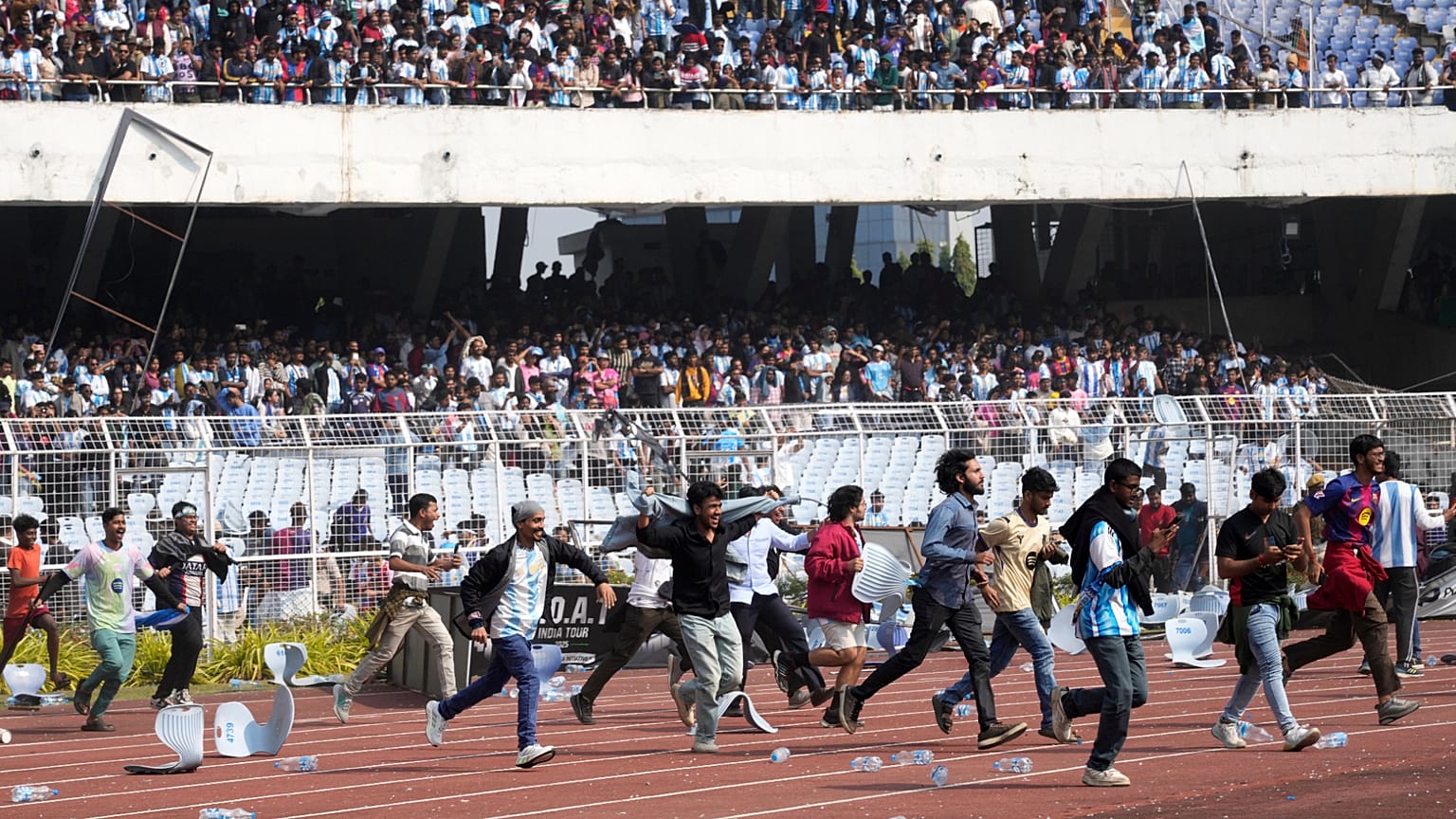 Angry Indian fans vandalize stadium chairs as they run on to the field after failing to get a glimpse of Argentine soccer star Lionel Messi at the Salt Lake Stadium, in India.