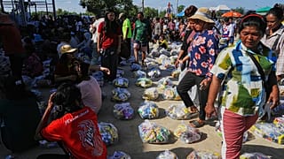 ينتظر النازحون استلام تبرعات من جمعية خيرية محلية لدى لجوئهم إلى بلدة بانتي مينتشي الإقليمية في كمبوديا، يوم السبت 13 ديسمبر/كانون الأول 2025