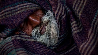  في هذه الصورة المؤرخة في 20 فبراير/شباط 2015، يظهر رجل هندي بلا مأوى نائماً مغطى ببطانية في الصباح الباكر في الأحياء القديمة من دلهي، الهند. 