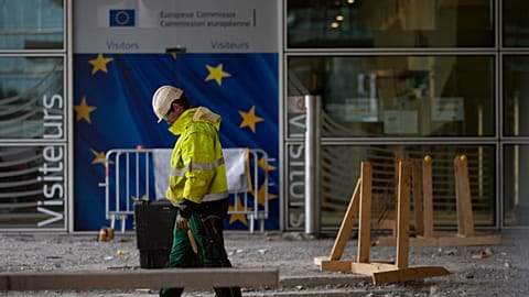 A construction worker stands in front of a door with the EU stars at EU headquarters in Brussels. 9 Oct. 2019.