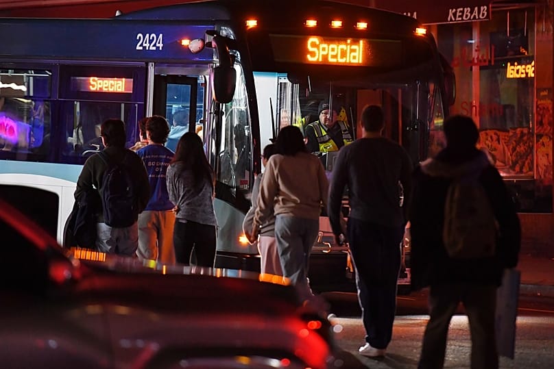 People board a bus in a neighborhood near Brown University, Saturday, Dec. 13, 2025, in Providence, R.I., during the investigation of a shooting.