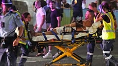نقل عمال الطوارئ شخصًا على نقالة بعد حادث إطلاق نار أُبلغ عنه على شاطئ بوندي في سيدني، يوم الأحد 14 ديسمبر 2025. (صورة أسوشيتد برس/مارك بيكر)
