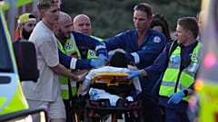 Equipas de emergência transportam uma pessoa numa maca após um tiroteio relatado em Bondi Beach.