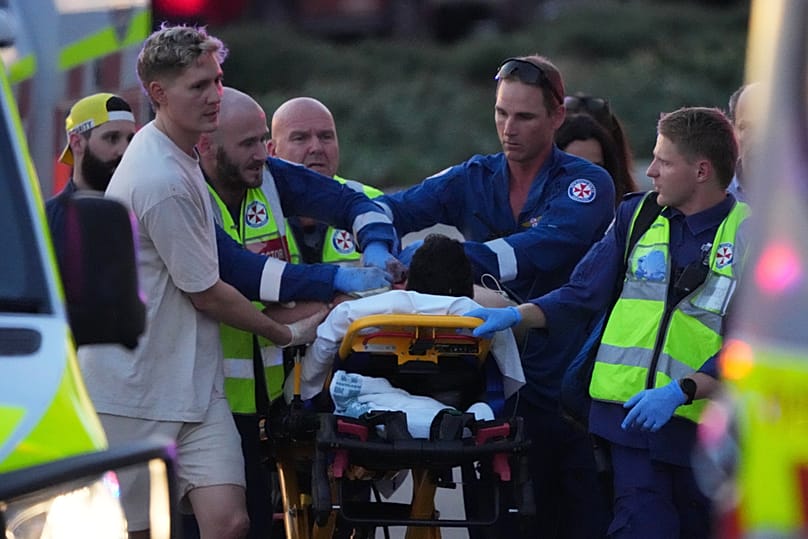 Les secours transportent une personne sur une civière après une fusillade signalée à Bondi Beach, à Sydney, dimanche 14 décembre 2025. 