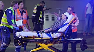 Emergency workers transport a person on a stretcher after a reported shooting at Bondi Beach in Sydney, Sunday, Dec. 14, 2025