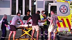 Sydney'deki Bondi Plajı'nda bildirilen bir silahlı saldırının ardından acil ekipler bir kişiyi sedyeyle taşıyor.