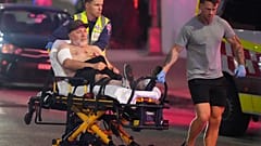 Emergency workers transport a person on a stretcher after a reported shooting at Bondi Beach in Sydney,