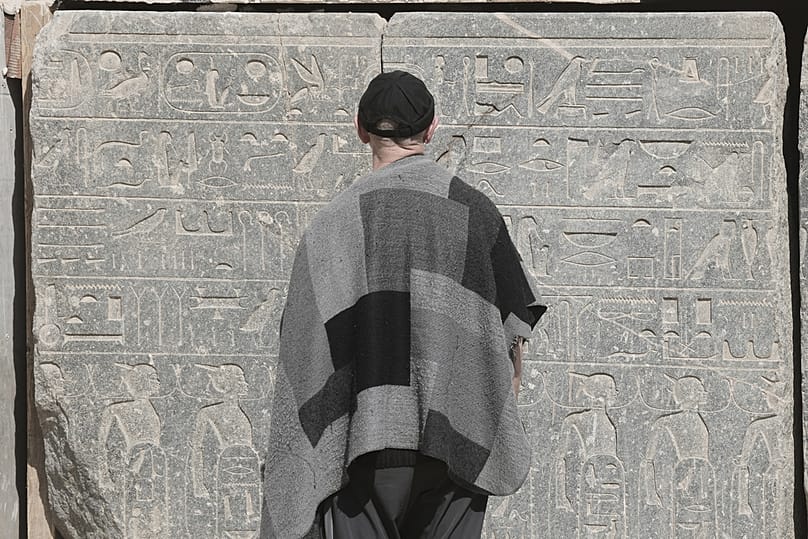 A visitor looks at the base of the reassembled alabaster statue for Pharoah Amenhotep III, in the southern city of Luxor, Egypt, Sunday, Dec. 14, 2025.