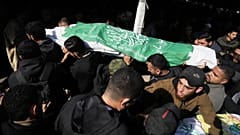 Des Palestiniens portent le corps d'un militant du Hamas drapé dans le drapeau du groupe, qui a été tué lors d'une frappe de l'armée israélienne, lors de ses funérailles dans la ville de Gaza, dimanche 14 décembre 2025.