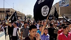 Διαδηλωτές φωνάζουν συνθήματα υπέρ του Ισλαμικού Κράτους, καθώς κρατούν τις σημαίες της οργάνωσης μπροστά από την έδρα της επαρχιακής διοίκησης στη Μοσούλη.