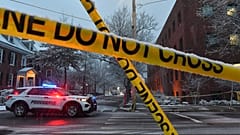 Un vehículo policial estacionado en una intersección cerca de la cinta de la escena del crimen en la Universidad de Brown, 14 de diciembre de 2025.