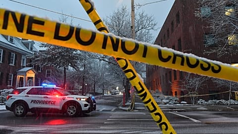 A police vehicle is parked at an intersection near crime scene tape at Brown University, 14 December 2025