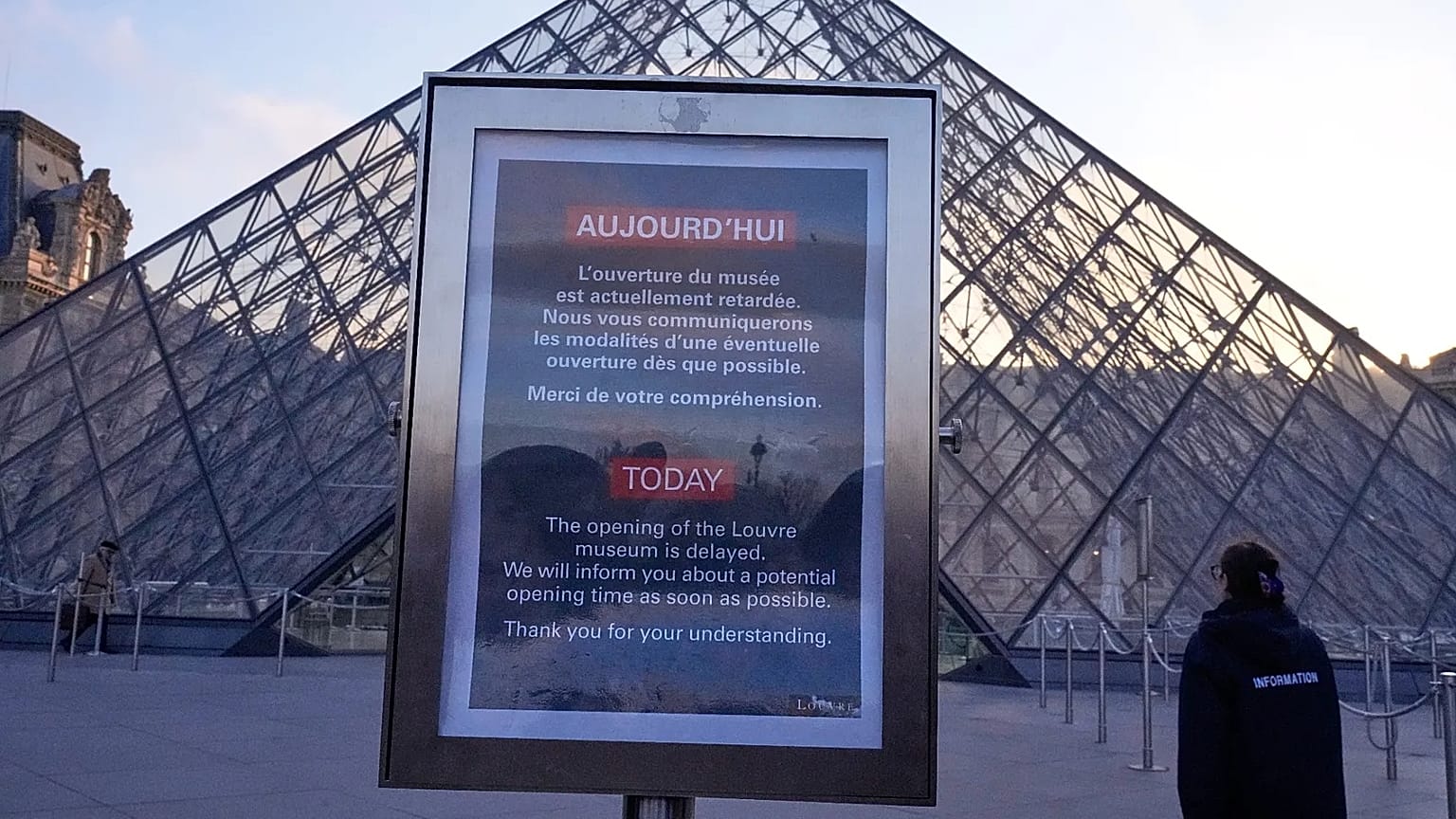 A board advises opening delays outside the pyramid of the Louvre museum in Paris, 15 December, 2025 