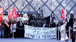 Des travailleurs brandissent des banderoles devant le musée du Louvre après avoir voté en faveur d'une journée de grève, le lundi 15 décembre 2025 à Paris