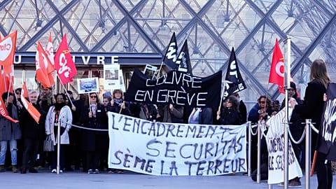 I lavoratori reggono degli striscioni all'esterno del Museo del Louvre dopo aver votato a favore di uno sciopero di un giorno lunedì 15 dicembre 2025 a Parigi.