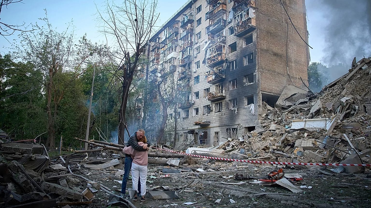 Des habitants réagissent après qu'un missile russe a touché un immeuble d'habitation lors d'une attaque aérienne combinée de missiles et de drones à Kiev, le 17 juin 2025.