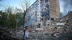 Des habitants réagissent après qu'un missile russe a touché un immeuble d'habitation lors d'une attaque aérienne combinée de missiles et de drones à Kiev, le 17 juin 2025.