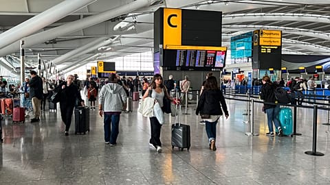 Passengers walk past the departures board at Heathrow Airport, in London, 28 August 2023.