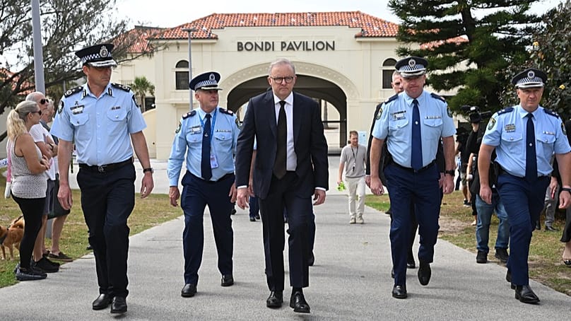 Le premier ministre australien Anthony Albanese, au centre, visite le pavillon de Bondi où il a déposé des fleurs à Bondi Beach à Sydney, le lundi 15 décembre 2025, un jour après la fusillade.