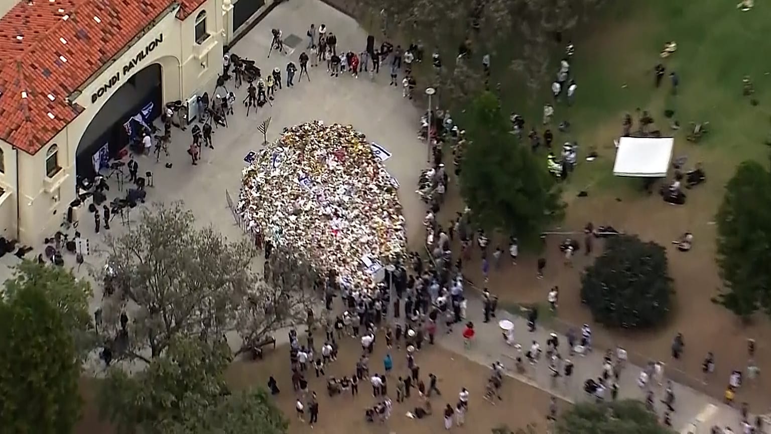 Вид с воздуха на огромное количество возложенных цветов на траурном бдении на пляже Бонди в Сиднее