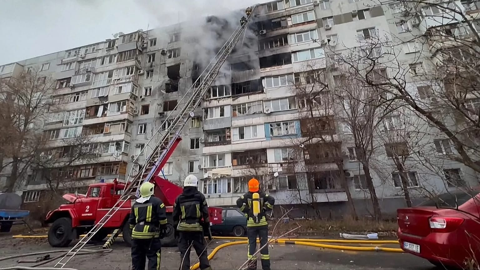 Firefighters look up at a residential building that was struck by a Russian drone, which injured several people. Tuesday, 16 December, 2025.