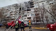 Firefighters look up at a residential building that was struck by a Russian drone, which injured several people. Tuesday, 16 December, 2025.