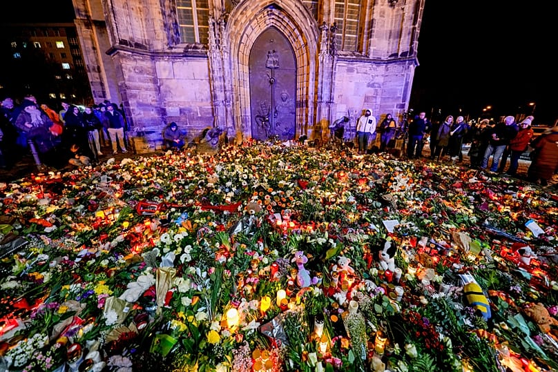 Цветы и свечи у входа в церковь Святого Иоанна в память о жертвах нападения на рождественский рынок,